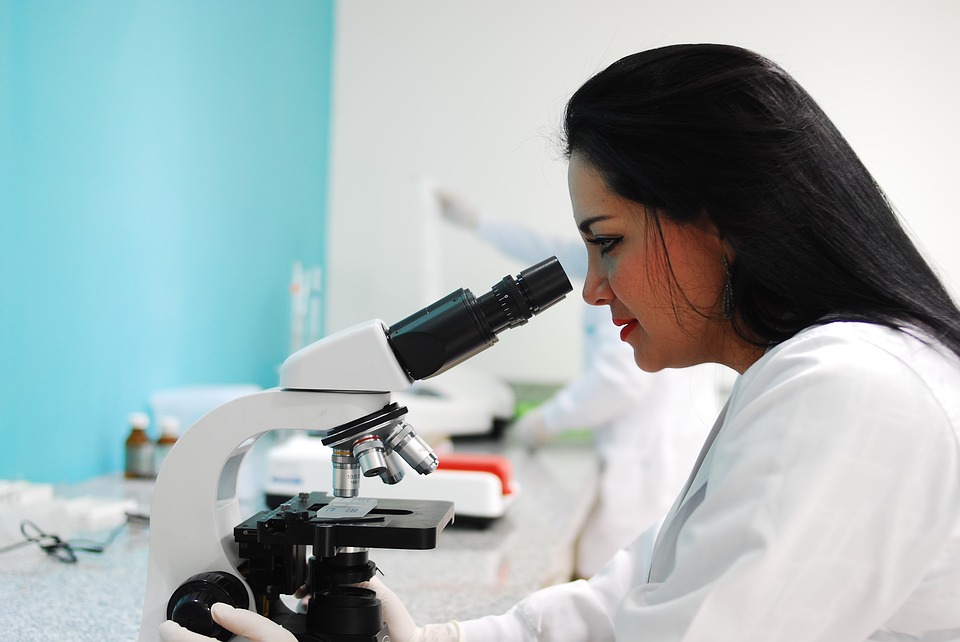 Scientist looking through microscope.