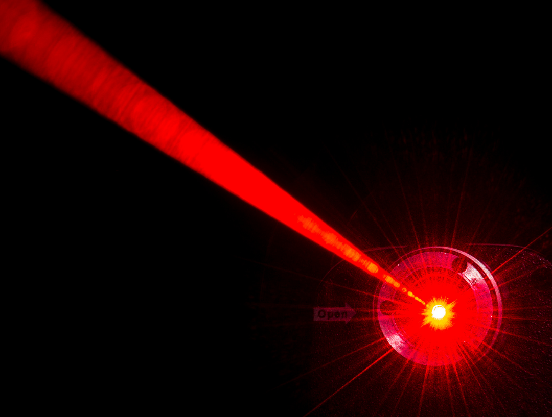 Red laser beam against a black background